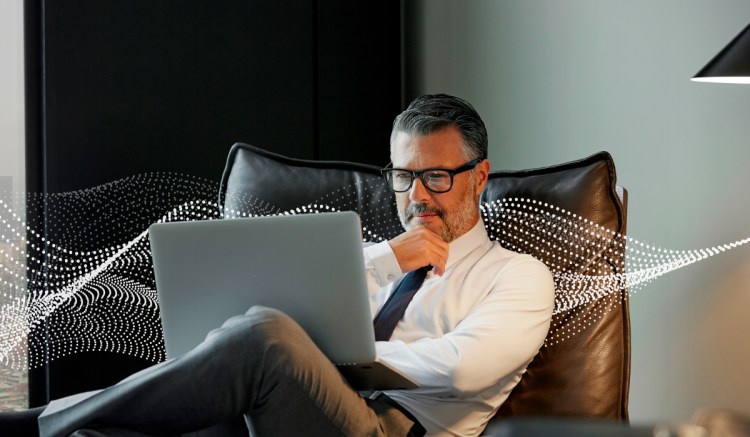 middle aged man sitting, remote working from of laptop