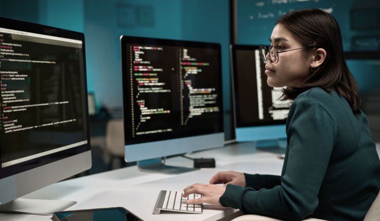 A woman looks at a computer screen to create AI Agents