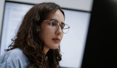 A woman uses AI-enabled tools within risk monitoring processes.