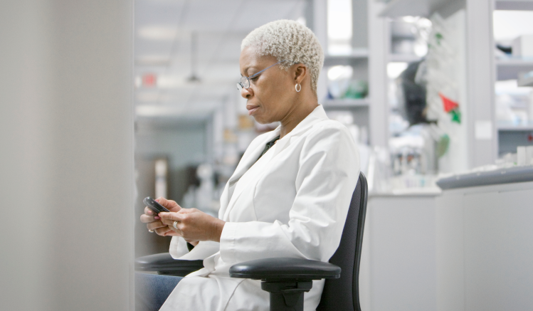 A pharmaceutical employee looking at her mobile device.