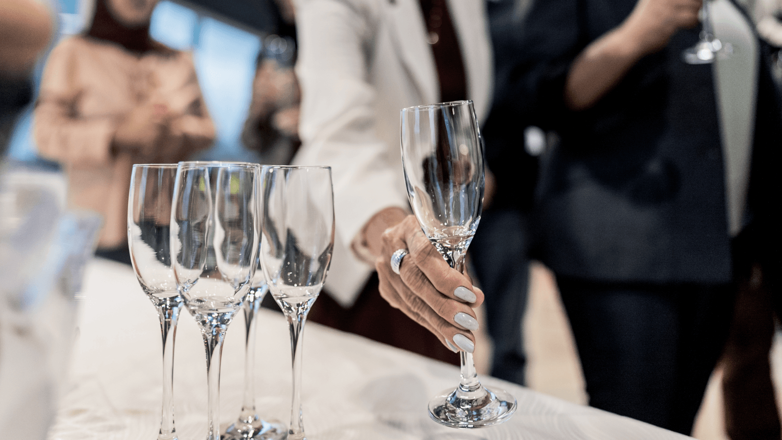 A business lady picking up a wine glass from a table