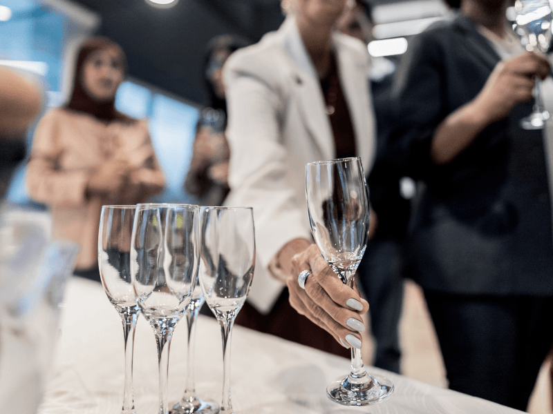 A business lady picking up a wine glass from a table